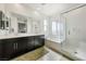 Bathroom showcasing dual sinks, large mirror, soaking tub, and glass shower with sleek finishes at 59 Strada Loreto, Henderson, NV 89011