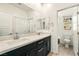 Bright bathroom features a double sink vanity, a large mirror, and a separate toilet room at 59 Strada Loreto, Henderson, NV 89011