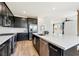 Bright kitchen featuring a large island, stainless steel appliances, and stylish black cabinets at 59 Strada Loreto, Henderson, NV 89011