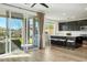 Bright kitchen features a large island with seating, sleek black cabinetry, and sliding glass doors to the backyard at 59 Strada Loreto, Henderson, NV 89011