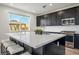 A modern kitchen featuring black cabinetry, a quartz countertop island, and stainless appliances at 59 Strada Loreto, Henderson, NV 89011