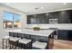 A modern kitchen featuring black cabinetry, a quartz countertop island, and stainless appliances at 59 Strada Loreto, Henderson, NV 89011