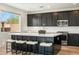 A modern kitchen featuring black cabinetry, a quartz countertop island, and stainless appliances at 59 Strada Loreto, Henderson, NV 89011