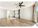 Spacious living room featuring wood-look floors, a modern ceiling fan, and large windows for plenty of natural light at 59 Strada Loreto, Henderson, NV 89011