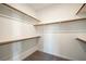 Spacious walk-in closet featuring carpeted floors and multiple shelves with wooden trim for ample storage at 59 Strada Loreto, Henderson, NV 89011