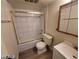 This bathroom features a tub with gold enclosure, toilet, vanity and a light wood framed mirror at 615 S Royal Crest Cir # 10, Las Vegas, NV 89169