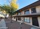 Two-story building with covered balcony, metal railings, large tree, and blue sky at 615 S Royal Crest Cir # 10, Las Vegas, NV 89169