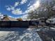 Attractive stucco home featuring a secure black metal fence with a drought-tolerant landscape and mature shade trees at 617 S 9Th St, Las Vegas, NV 89101