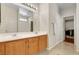 Bathroom with double sinks, wooden cabinets, and a large mirror and a walk-in closet at 6190 Tillman Crest Ave, Las Vegas, NV 89139