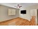 Well-lit bedroom featuring wood floors, a modern ceiling fan, and a wall-mounted TV at 6190 Tillman Crest Ave, Las Vegas, NV 89139