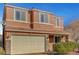 Two-story home with a neutral-toned exterior, a two-car garage, and manicured landscaping at 6190 Tillman Crest Ave, Las Vegas, NV 89139