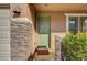 Close-up of a green front door framed by stone pillars and lush greenery at 6190 Tillman Crest Ave, Las Vegas, NV 89139