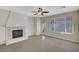 A fireplace and large window brighten this living room with tile floor and ceiling fan at 6190 Tillman Crest Ave, Las Vegas, NV 89139