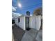 View of a detached structure with a block fence, white stucco, a black security door and a white entry door at 621 S 9Th St, Las Vegas, NV 89101