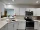 Bright kitchen with white cabinetry, stainless appliances, and a pass-through to the living space at 621 S 9Th St, Las Vegas, NV 89101