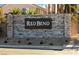 Stone sign for the Red Bend community, set amid lush greenery at 6598 Tumoulin St, Las Vegas, NV 89148