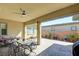 Inviting covered patio has stone flooring, a ceiling fan, and seating, perfect for dining at 6722 Desert Crimson St, Las Vegas, NV 89148