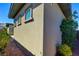 Neutral stucco exterior with framed windows and verdant shrubs provides appealing curb appeal at 6722 Desert Crimson St, Las Vegas, NV 89148