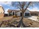 Attractive home featuring a tile roof, a two-car garage, and desert landscaping with rocks and trees at 7505 Crystal Clear Ave, Las Vegas, NV 89113