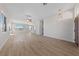 Bright living room features wood flooring, a ceiling fan, and a large window bringing in natural light at 7505 Crystal Clear Ave, Las Vegas, NV 89113