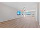 Bright living room features wood flooring, a ceiling fan, and large windows bringing in natural light at 7505 Crystal Clear Ave, Las Vegas, NV 89113