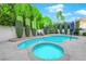 Backyard pool and spa surrounded by lush greenery, creating a serene and private outdoor retreat at 7632 Desert Largo Ave, Las Vegas, NV 89128