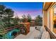 Inviting outdoor balcony seating area, with stone columns, overlooking a lush landscape and pool at 801 Sir James Bridge Way, Las Vegas, NV 89145