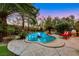 Tranquil backyard pool surrounded by mature trees and a rock waterfall feature at 801 Sir James Bridge Way, Las Vegas, NV 89145