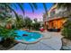 Inviting backyard pool area with mature landscaping, a stone accent wall, and comfortable patio furniture at 801 Sir James Bridge Way, Las Vegas, NV 89145