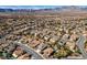 An aerial view showcases this desert community with neutral-colored homes and mountain views at 941 Armandito Dr, Las Vegas, NV 89138