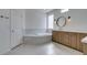 Bathroom featuring a soaking tub, wood cabinets, marble countertops, and brass fixtures at 941 Armandito Dr, Las Vegas, NV 89138