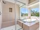 Bright bathroom with a walk-in shower, tub and large windows at 1 Ibis Ct, Henderson, NV 89052