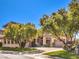 Inviting home with lush green lawn and mature trees creating a picturesque street view on a bright day at 1 Ibis Ct, Henderson, NV 89052