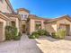 Beautiful home exterior with a well-manicured lawn and elegant arched doorway, set against a clear blue sky at 1 Ibis Ct, Henderson, NV 89052