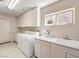 Well-lit laundry room featuring a washer, dryer, sink, and ample storage space with white cabinets at 1 Ibis Ct, Henderson, NV 89052