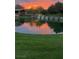 Scenic community pond with a waterfall and vibrant sunset reflections on the water, creating a serene and picturesque setting at 1 Ibis Ct, Henderson, NV 89052