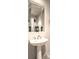 Powder room featuring a pedestal sink, modern fixtures, and a decorative mirror at 1 Ibis Ct, Henderson, NV 89052