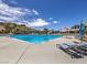 Inviting community pool with lounge chairs, umbrellas, and a lifeguard stand, perfect for relaxation and recreation on sunny days at 1 Ibis Ct, Henderson, NV 89052