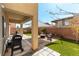 Backyard with outdoor kitchen setup, seating, artificial turf and shaded patio area at 10745 Leatherstocking Ave, Las Vegas, NV 89166