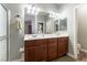 Bathroom vanity with dual sinks, great lighting, and wooden cabinets at 10745 Leatherstocking Ave, Las Vegas, NV 89166