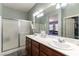 Bathroom features dual sinks, a large mirror, and a shower with glass door at 10745 Leatherstocking Ave, Las Vegas, NV 89166