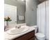 Tastefully designed half-bath features a toilet and sink with a cream-colored shower curtain at 10745 Leatherstocking Ave, Las Vegas, NV 89166