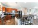 Open kitchen featuring stainless steel appliances, a granite island with seating, and wood-look flooring at 10745 Leatherstocking Ave, Las Vegas, NV 89166