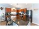 Spacious kitchen with dark appliances, wood cabinets, granite counters, an island, and recessed lighting at 10745 Leatherstocking Ave, Las Vegas, NV 89166