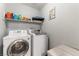 Efficient laundry room with modern washer and dryer set, and storage shelving at 10745 Leatherstocking Ave, Las Vegas, NV 89166