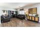 Well-lit living room featuring hardwood flooring, a large entertainment center and comfortable seating at 10745 Leatherstocking Ave, Las Vegas, NV 89166