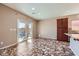 Open-concept living room featuring sliding glass doors, tile flooring, and kitchen island with breakfast bar at 10746 Lightning Sky St, Las Vegas, NV 89179