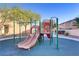 Community playground features a slide, climbing structure, swings and shaded bench at 11103 African Sunset St, Henderson, NV 89052