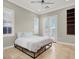Comfortable bedroom featuring neutral colors, tiled floor and access to a patio through white shuttered French doors at 11354 Merado Peak Dr, Las Vegas, NV 89135