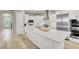 Bright kitchen boasts white cabinets, stainless steel appliances, and a large island with seating at 11354 Merado Peak Dr, Las Vegas, NV 89135